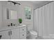 Bright bathroom featuring a modern vanity, updated fixtures, and a shower with white shower curtains at 7213 Baniff Cir, Charlotte, NC 28277