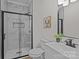 Modern bathroom featuring a sleek glass shower with marble-style tile, a white vanity, and contemporary fixtures at 7213 Baniff Cir, Charlotte, NC 28277