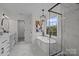 Beautiful bathroom featuring a soaking tub, glass shower and marble tile at 7213 Baniff Cir, Charlotte, NC 28277