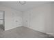 Neutral bedroom with gray carpeting, multiple doors, and an electrical outlet at 7213 Baniff Cir, Charlotte, NC 28277