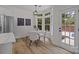 Cozy breakfast nook with bay windows, a modern chandelier, and a door leading to the outdoor pool area at 7213 Baniff Cir, Charlotte, NC 28277