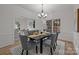 Formal dining room with seating for six, stylish chandelier, and view to the living area at 7213 Baniff Cir, Charlotte, NC 28277