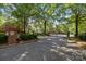 View of a gated neighborhood entrance featuring brick pillars, wrought iron gates, and mature landscaping at 7213 Baniff Cir, Charlotte, NC 28277