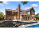 Exterior of home featuring a backyard swimming pool, brick siding, black metal fence, patio, and mature trees at 7213 Baniff Cir, Charlotte, NC 28277