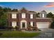 Charming brick two-story home with well-maintained landscaping, complemented by dark shutters and a welcoming front entrance at 7213 Baniff Cir, Charlotte, NC 28277