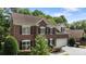 Traditional brick home featuring black shutters, a two-car garage, well-maintained landscaping and mature trees at 7213 Baniff Cir, Charlotte, NC 28277