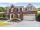 Beautiful brick two-story home with lush landscaping, a two car garage, and a covered front entrance at 7213 Baniff Cir, Charlotte, NC 28277