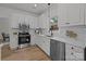 Updated kitchen with white cabinets, stainless steel appliances, and modern fixtures at 7213 Baniff Cir, Charlotte, NC 28277