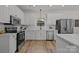 Well-lit kitchen with white cabinets, stainless steel appliances, and a subway tile backsplash at 7213 Baniff Cir, Charlotte, NC 28277