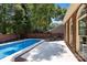 Backyard pool featuring a brick border and patio area, surrounded by mature trees and a brick wall at 7213 Baniff Cir, Charlotte, NC 28277