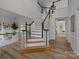 Grand staircase featuring wooden treads, white risers, and a black handrail leading to the upper level at 7213 Baniff Cir, Charlotte, NC 28277