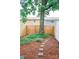 Backyard features wooden fence, stepping stones, and mature shade tree at 7526 Holly Grove Ct, Charlotte, NC 28227