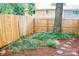 Backyard features wooden fence, stepping stones, and mature shade tree at 7526 Holly Grove Ct, Charlotte, NC 28227