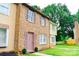 Brick townhome showcasing its charming side profile with a well-kept lawn and pink shutter accents at 7526 Holly Grove Ct, Charlotte, NC 28227