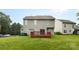 Home's rear exterior features a spacious yard and small wooden deck at 9637 Brookmere Ln, Charlotte, NC 28214