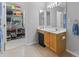 Well-lit bathroom with a vanity and sink adjacent to a walk-in closet with shoe racks at 9637 Brookmere Ln, Charlotte, NC 28214