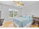 Cozy bedroom featuring light blue bedding, natural light from double windows, and light hardwood floors at 9637 Brookmere Ln, Charlotte, NC 28214