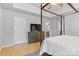 Bedroom with gray walls, a large television, and a glimpse into an adjoining bathroom at 9637 Brookmere Ln, Charlotte, NC 28214