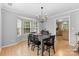 Dining room with a dark wood table, chandelier and hardwood floors adjacent to the kitchen at 9637 Brookmere Ln, Charlotte, NC 28214