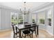 Dining room with a dark wood table, chandelier and views of the landscaped front yard at 9637 Brookmere Ln, Charlotte, NC 28214