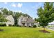 Traditional two-story home with a lovely green lawn and mature shade trees at 9637 Brookmere Ln, Charlotte, NC 28214