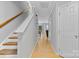 Hallway leading to living area, stairs and front door with wood flooring and neutral walls at 9637 Brookmere Ln, Charlotte, NC 28214
