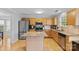 Bright kitchen features stainless appliances, a center island, and light wood cabinets and flooring at 9637 Brookmere Ln, Charlotte, NC 28214