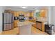 Bright kitchen features stainless appliances, a center island, and light wood cabinets and flooring at 9637 Brookmere Ln, Charlotte, NC 28214