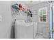 Laundry room with a washer, dryer, shelving, and a window for natural light at 9637 Brookmere Ln, Charlotte, NC 28214
