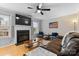 Inviting living room featuring a fireplace, ceiling fan, and hardwood floors at 9637 Brookmere Ln, Charlotte, NC 28214
