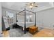 The main bedroom features a four-poster bed, neutral walls and carpet, and lots of natural light at 9637 Brookmere Ln, Charlotte, NC 28214