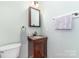 Powder room featuring a wooden vanity with granite countertops, and modern fixtures at 1002 Hollyhedge Ln, Indian Trail, NC 28079