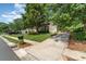 Inviting single-Gathering home boasts a well-manicured lawn, mature trees, and a long driveway leading to an attached garage at 1002 Hollyhedge Ln, Indian Trail, NC 28079