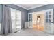 Cozy living room with large windows, neutral carpet, and French doors, offering ample natural light and a seamless transition at 1002 Hollyhedge Ln, Indian Trail, NC 28079