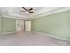 Spacious main bedroom featuring neutral carpet, a ceiling fan and a door to the ensuite bath at 1002 Hollyhedge Ln, Indian Trail, NC 28079