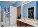 Well-lit bathroom featuring a single sink vanity, a shower with curtain, and a mirrored closet for storage at 1012 Laparc Ln, Indian Trail, NC 28079
