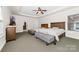 Bright bedroom with two beds, gray benches, tray ceilings, carpet floors, and a ceiling fan at 10321 Lemington Dr, Mint Hill, NC 28227