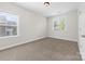 Bedroom with neutral carpet, natural light, base trim and a window with wooded view at 10321 Lemington Dr, Mint Hill, NC 28227