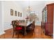 Formal dining room featuring hardwood floors, chandelier, large wood table, and ample natural light at 10321 Lemington Dr, Mint Hill, NC 28227