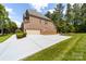 Long concrete driveway leading to a two-car garage, surrounded by well-maintained lawn and greenery at 10321 Lemington Dr, Mint Hill, NC 28227