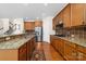 Spacious kitchen with granite countertops, wooden cabinets, and stainless steel appliances, connecting to stairs at 10321 Lemington Dr, Mint Hill, NC 28227