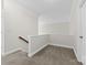 Upstairs landing featuring neutral carpet, white walls and trim and a half wall with wood railing at 10321 Lemington Dr, Mint Hill, NC 28227