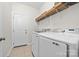Bright laundry room featuring modern washer and dryer, wire shelving, and tile flooring at 10321 Lemington Dr, Mint Hill, NC 28227