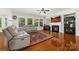 Cozy living room with hardwood floors, fireplace, large windows, and comfortable seating for relaxation at 10321 Lemington Dr, Mint Hill, NC 28227