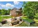 Inviting backyard with stone fire pit, wooden benches, and lush lawn for outdoor enjoyment at 10321 Lemington Dr, Mint Hill, NC 28227