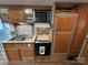 Functional kitchen with stainless steel sink, oven, microwave, and wooden cabinets at 109 Pine St, New London, NC 28127