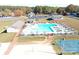 Aerial view of a large pool with chairs and umbrellas, a basketball court, and a volleyball area at 109 Pine St, New London, NC 28127