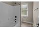 Bathroom with white tiled shower and tub combination and window for natural light at 126 Northbridge Dr, Mooresville, NC 28115
