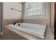 Bathroom featuring a large soaking tub with tile surround and a window at 126 Northbridge Dr, Mooresville, NC 28115