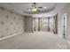 Large bedroom featuring a tray ceiling with fan and a wall of windows at 126 Northbridge Dr, Mooresville, NC 28115